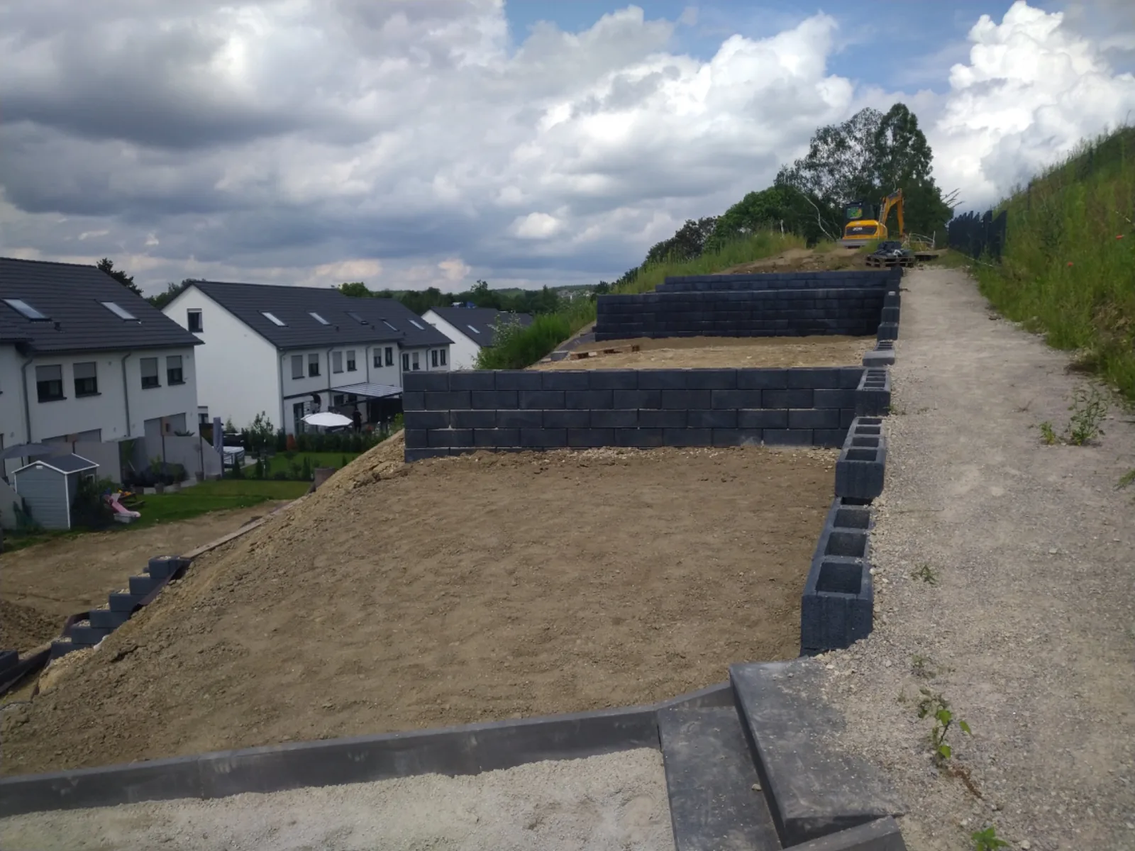 Fertig modellierter Hanggarten mit Mauern und Treppe, umgesetzt von AT Bau