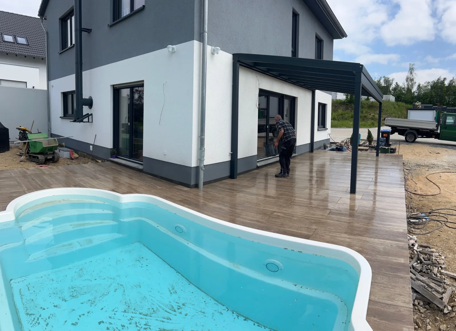 Eingesetztes Poolbecken mit umlaufender Terrassenfläche am Wohnhaus