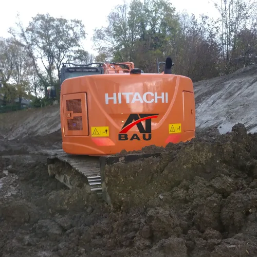 Hitachi-Bagger mit AT-BAU-Beschriftung im Einsatz